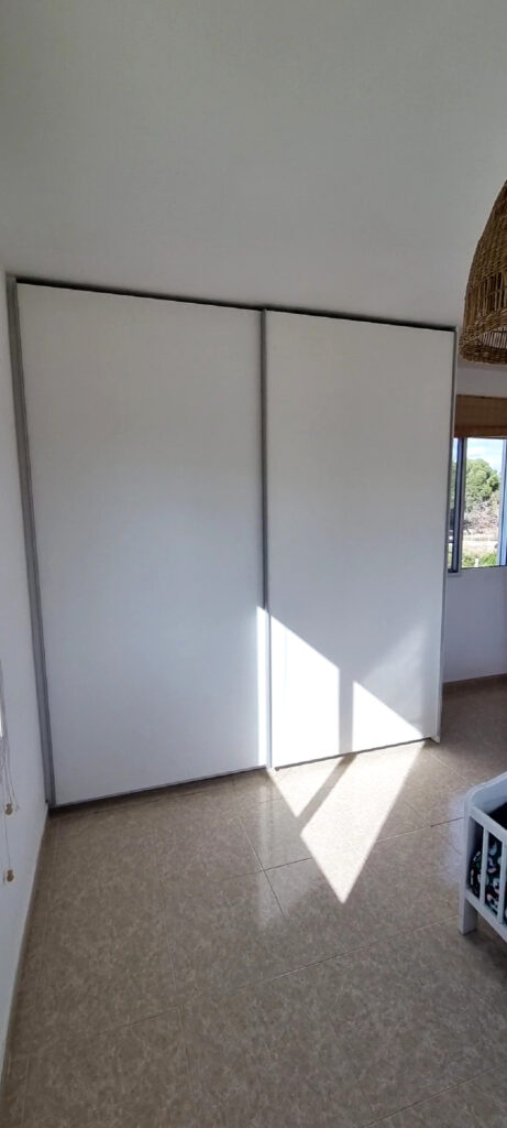 armario blanco maderas Armario blanco. Es un armario empotrado con dos puertas, parece hecho para una habitación pequeña. Está cerrado. Hecho a medida.