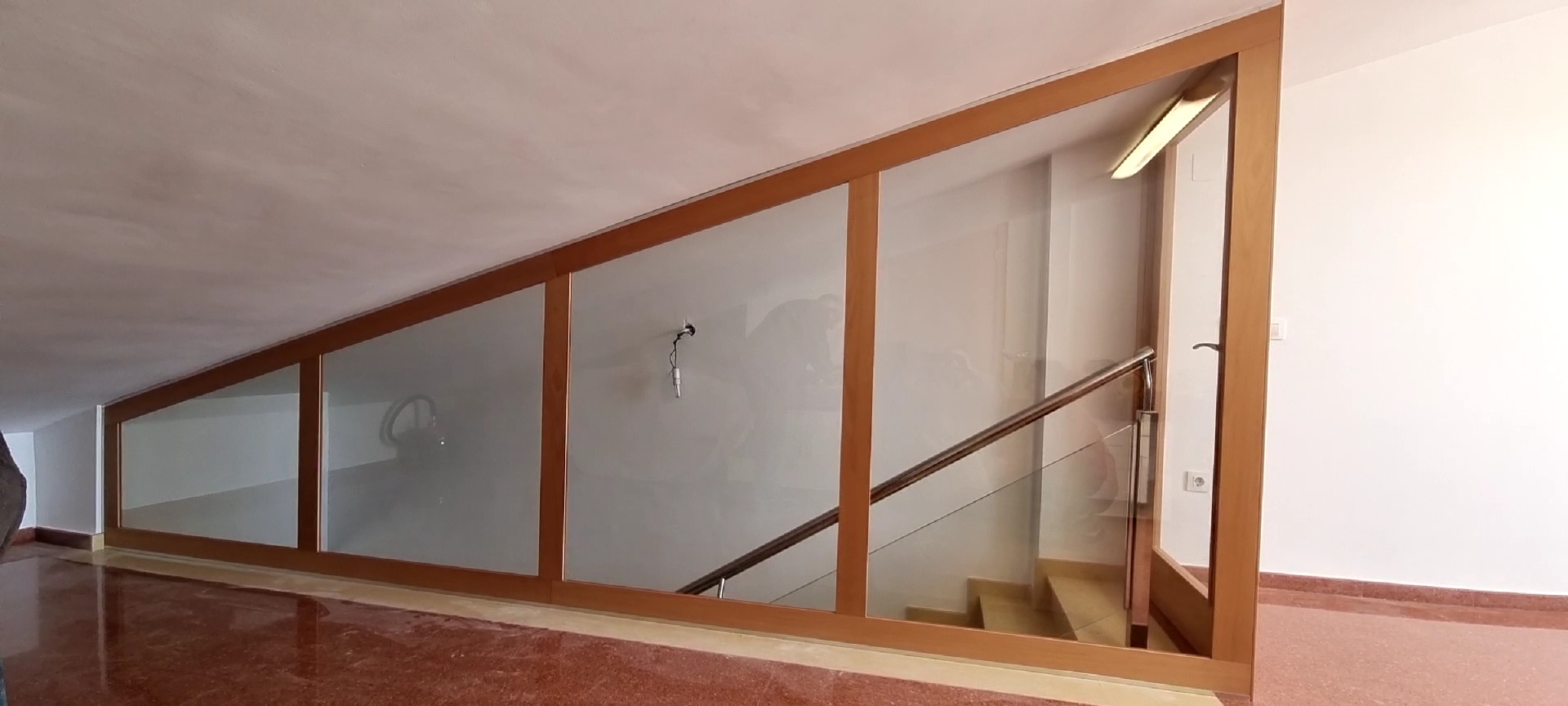 Cerramiento de madera hecho a medida, con cristales con puerta incluida.