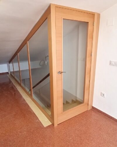 Cerramiento de madera hecho a medida, con cristales con puerta incluida.