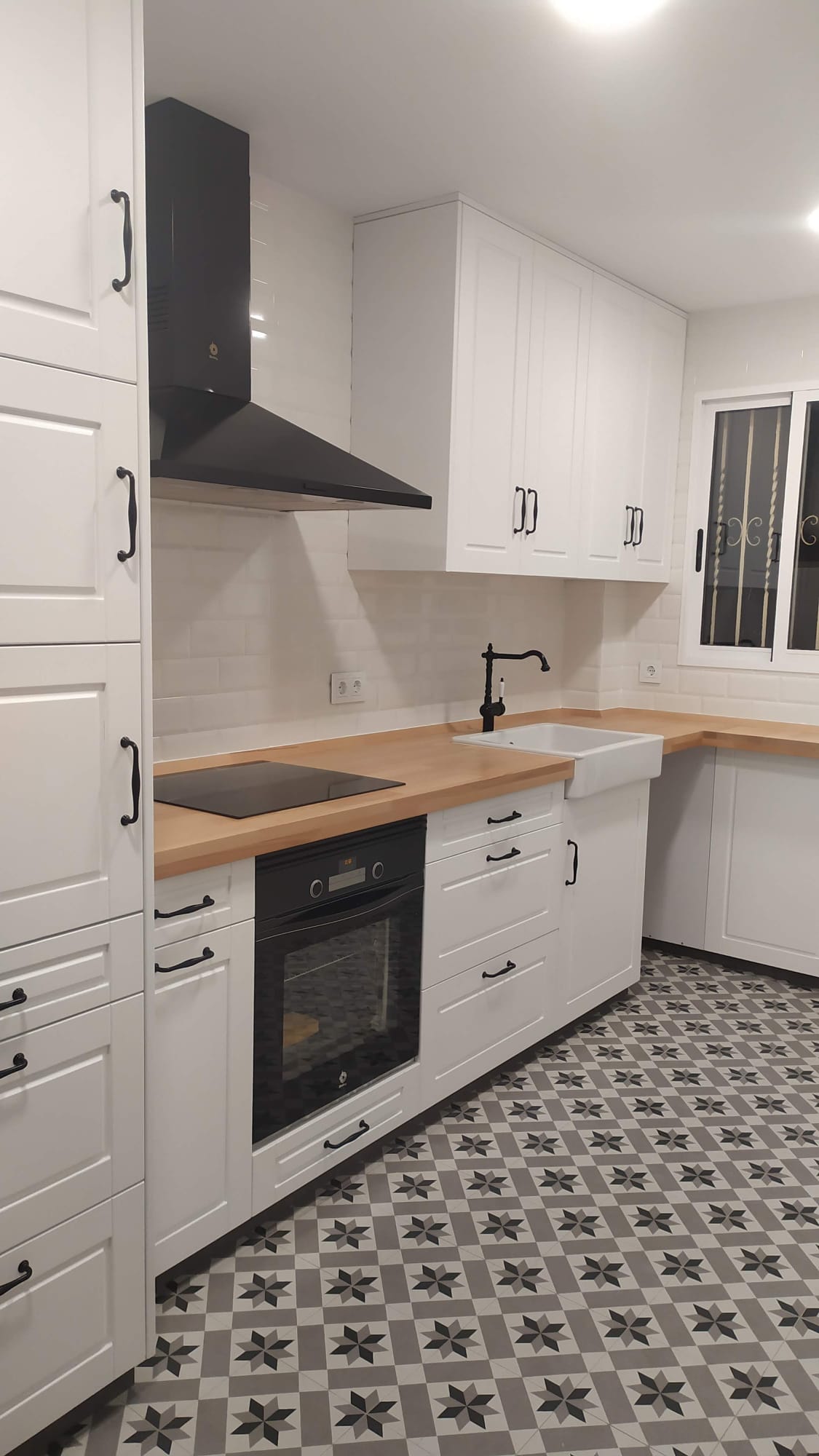 Muebles blancos de cocina con encimera clara puertas y cajones de madera hecho a medida.