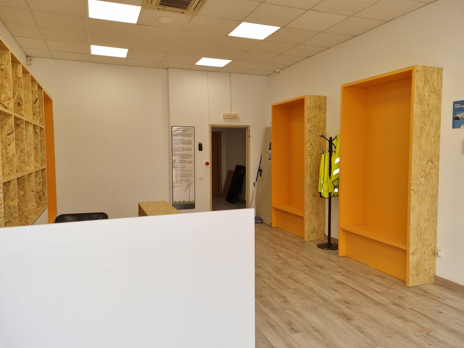 Estantería madera Estanterías de madera para una empresa hechas a medida, con interior color naranja.